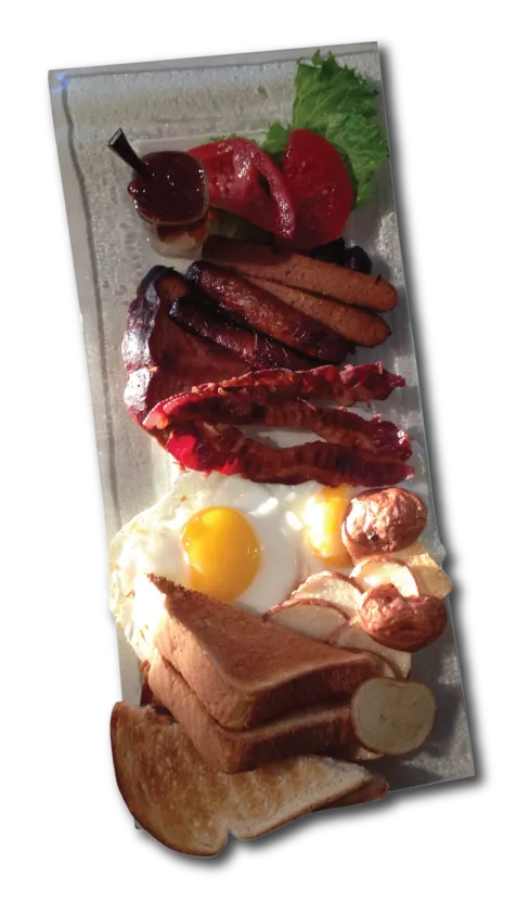 Assiette garnie : œufs au miroir, rôties, bacon, saucisses, pommes de terre, tomates et laitue