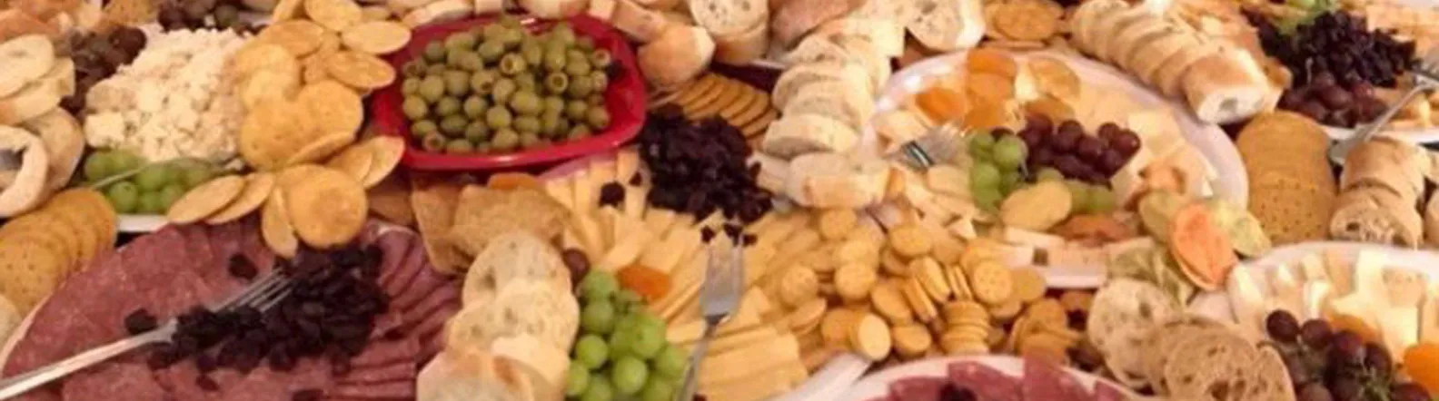 Grande table de buffet : charcuteries, fromages, craquelins, pains, olives et raisins