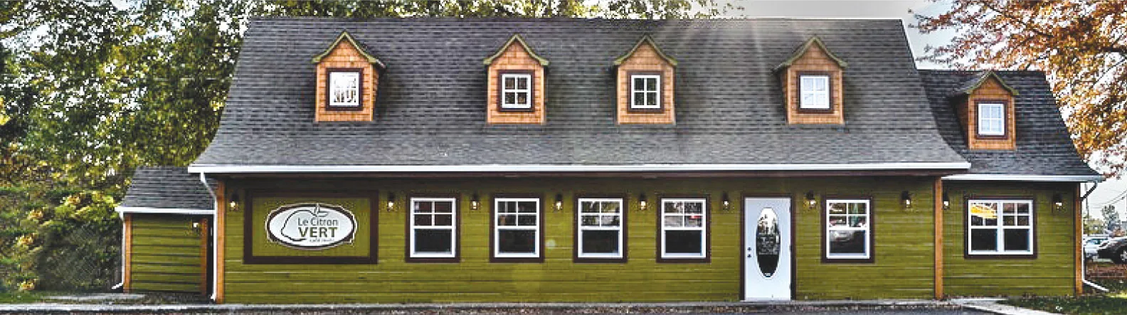 Façade du Citron Vert Café Resto : bâtiment vert aux lucarnes de bois et enseigne au logo